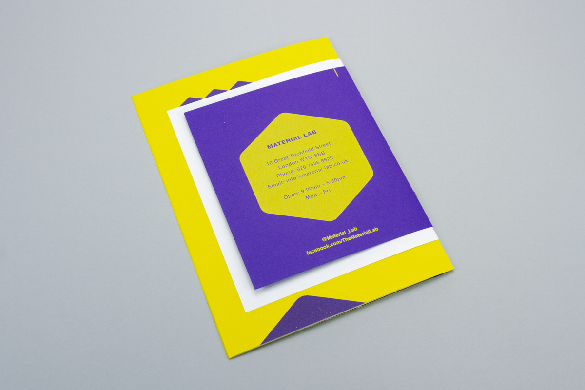 The reverse of the booklet. The back page is purple with a screen printed yellow hexagon. As the cover is smaller that the inner pages, the yellow and white inner pages can be seen poking out above, below and to the left.